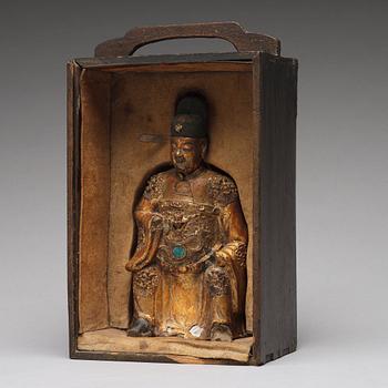 A lacquered and gilt ceramic sculpture of a deity, Ming dynasty (1368-1644).