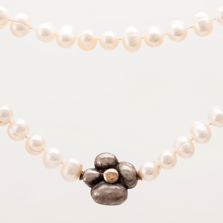A cultured pearl necklace with a silver lock set with a round brilliant cut diamond.