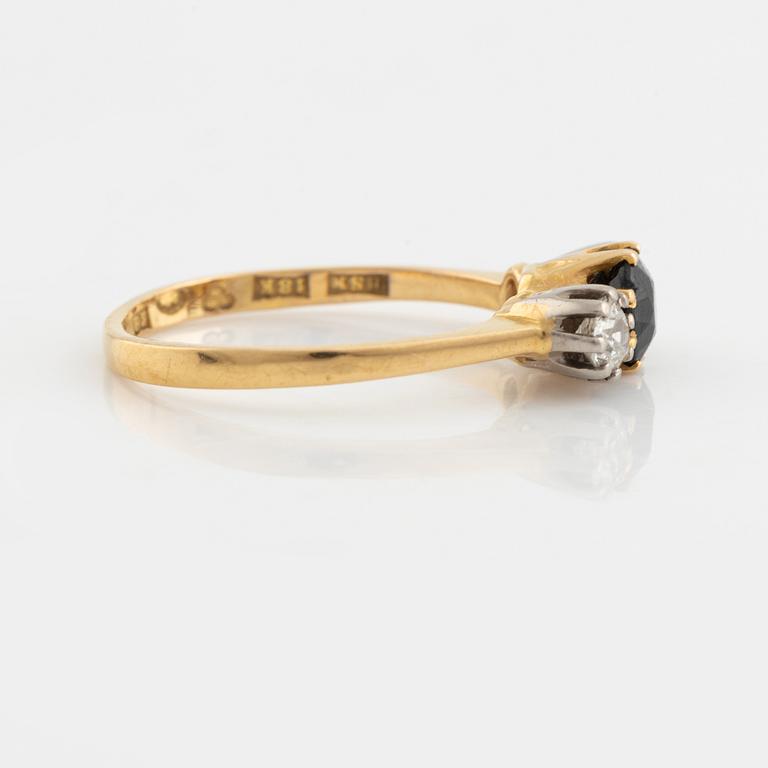 An 18K gold ring set with a sapphire and old-cut diamonds.