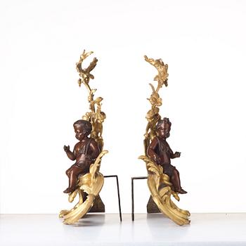 A pair of Louis XV-style 19th century fire dogs.