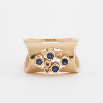 A ring set with four, round, mixed- cut, probably synthetic sapphires.
