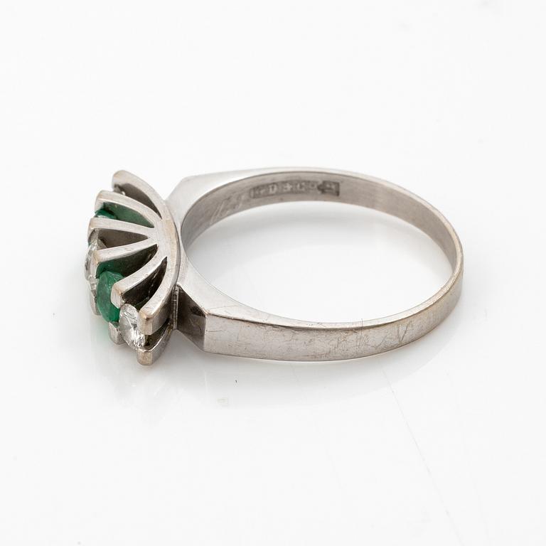 18K white gold ring set with round brilliant-cut diamonds and emeralds.