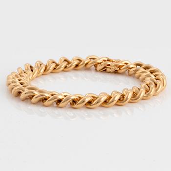 An 18K gold curb link bracelet.