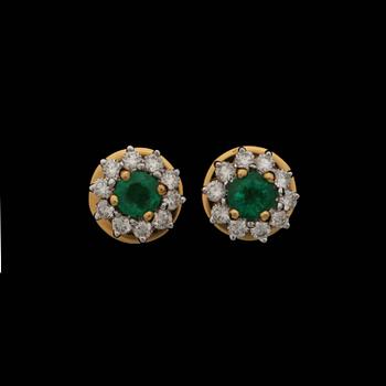 119. A pair of emerald earrings set with brilliant cut diamonds.
