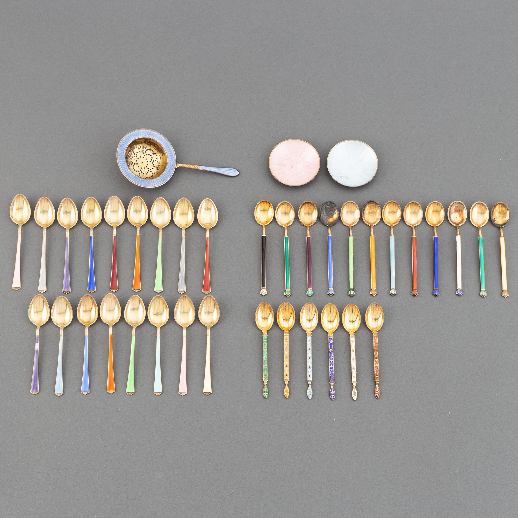 A mixed lot of 35 silver spoons, a tea strainer and two small dishes, parcel-gilt guilloché enamel, Norway, 20th century.