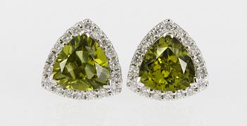 655. ÖRHÄNGEN, peridot med krans av briljantslipade diamanter, tot. ca 1 ct.