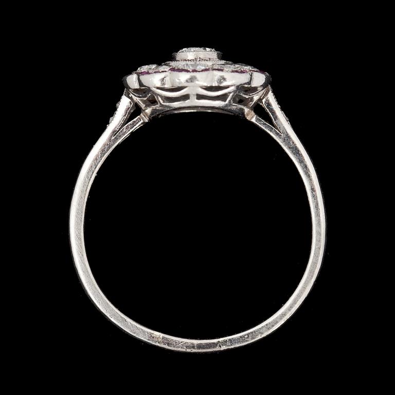 RING, platina besatt med briliantslipade diamanter tot ca 0,56 ct och små rubiner, 1900-talets mitt. Vikt ca 3,8 g.