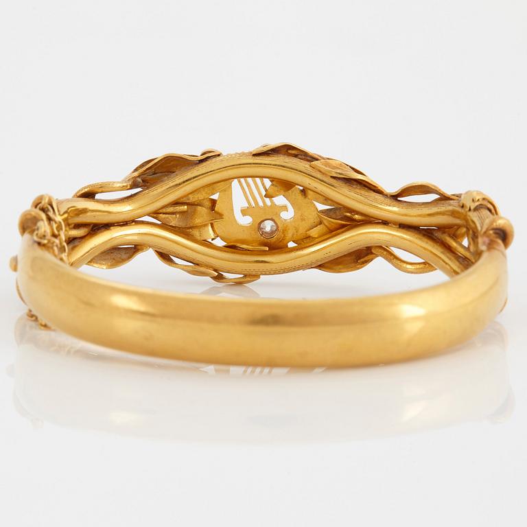 An 18K gold bangle set with an old-cut diamond.