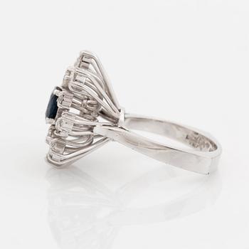 An 18K white gold ring set with a faceted sapphire and old-cut diamonds.