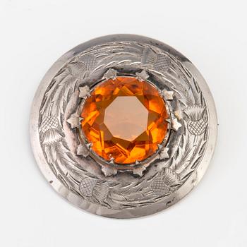 A BROOCH set with amber coloured paste.