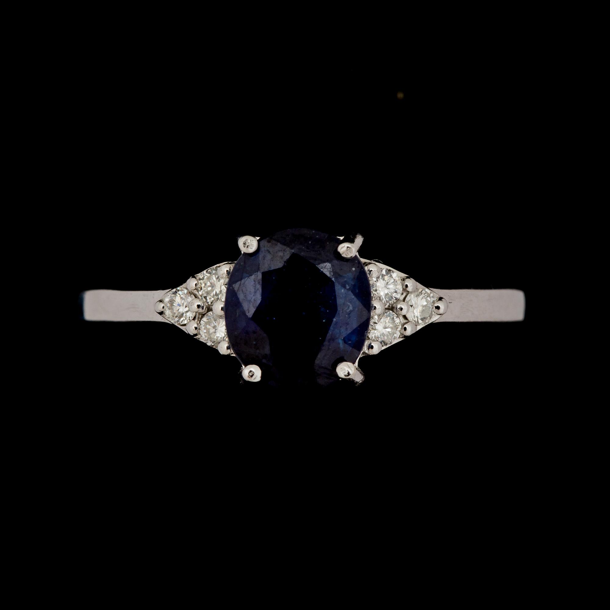 RING, 14 k vitguld med safir ca 1,32 ct, samt 6 mindre briljantslipade diamanter ca 0,06 ct. Vikt ca 2 g.