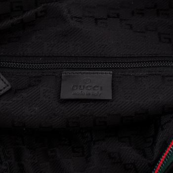 Gucci, a black canvas backpack.