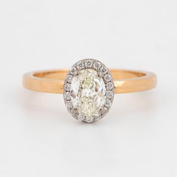 An 18k gold ring set with an oval brilliant-cut diamond.