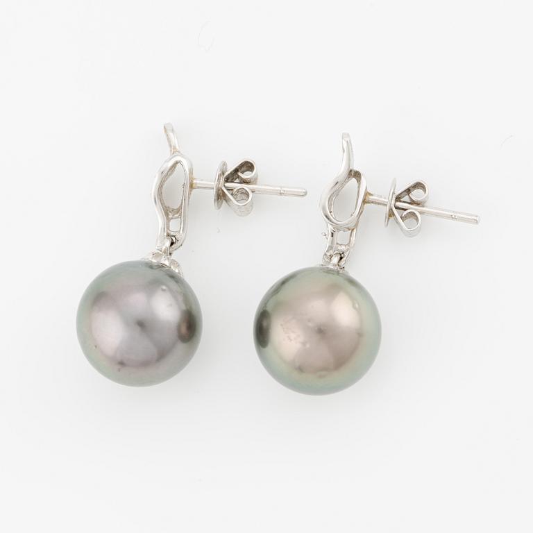 A pair of 18K gold earrings with cultured Tahitian pearls and white stones.