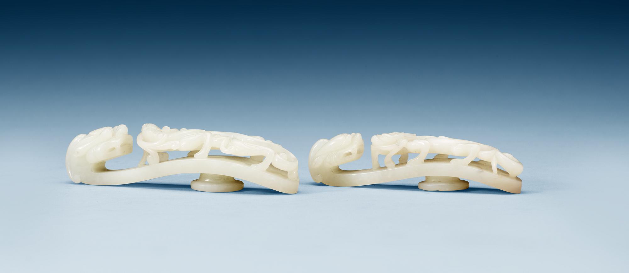 Two pale green nephrite garment hooks, Qing dynasty.