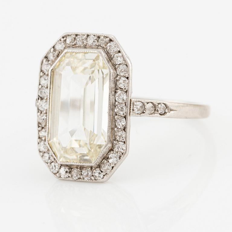 A platinum ring set with an emerald-cut diamond.