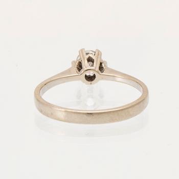 An 18K white gold solitaire ring set with a round brilliant-cut diamond.