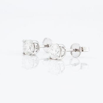 A pair of brilliant cut diamond earrings.