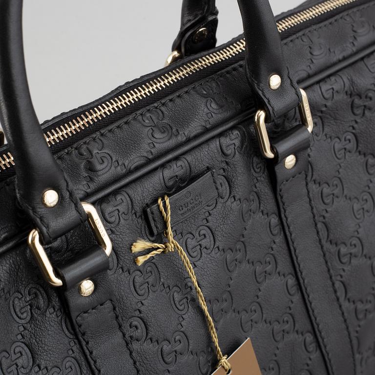 Gucci, a monogram leather bag/laptop-bag.