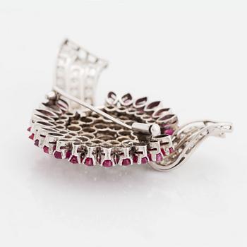 An 18K white gold brooch set with round brilliant-cut diamonds and navette-cut rubies.