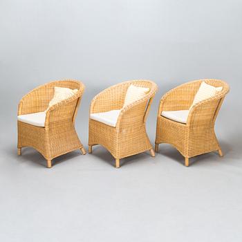 Three turn of the 21st century rattan lounge chairs.