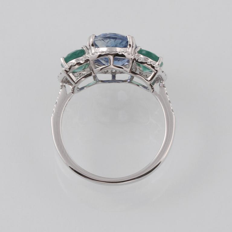 RING, 18K vitguld med fasettslipad kyanit 3.49 ct, 2 smaragder 1.23 ct och briljantslipade diamanter 0.33 ct. Vikt 3 g.