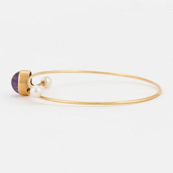 A bangle set with a cabochon-cut amethyst and cultured pearls.