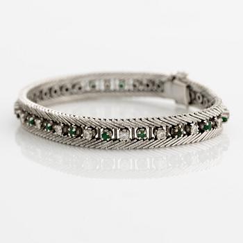 Bracelet 18K gold with round brilliant-cut diamonds and green stones, likely emeralds.