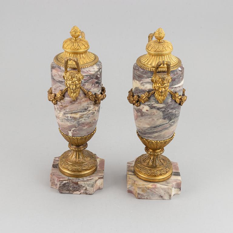 A pair of marble urns with bronze mountings from around year 1900.
