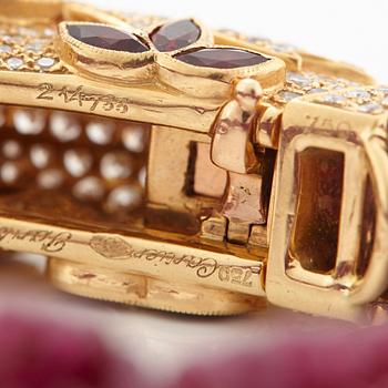 A Cartier chimera head bracelet in 18K gold set with round brilliant-cut diamonds and faceted rubies.