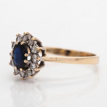 A 14K gold ring, with an oval faceted sapphire and diamonds, England.