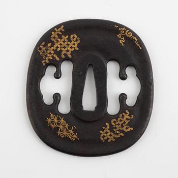 An iron part gilt Japanese tsuba, Edo (1603-1868). In a kiri box.