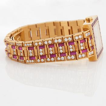 A Bulgari wristwatch in 18K gold set with step-cut rubies and round brilliant-cut diamonds.