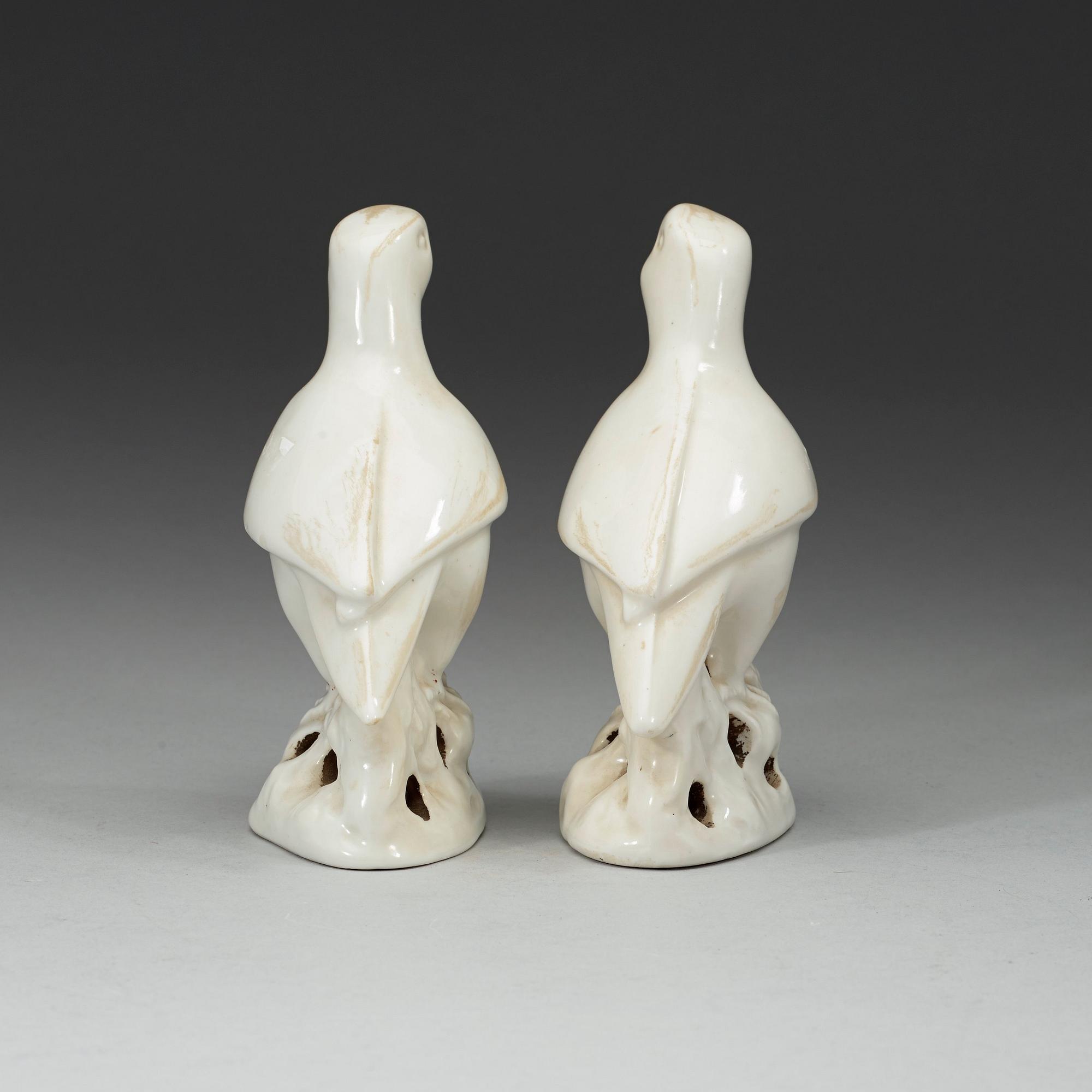 A pair of white and red glazed figures of parrots, late Qing dynasty.