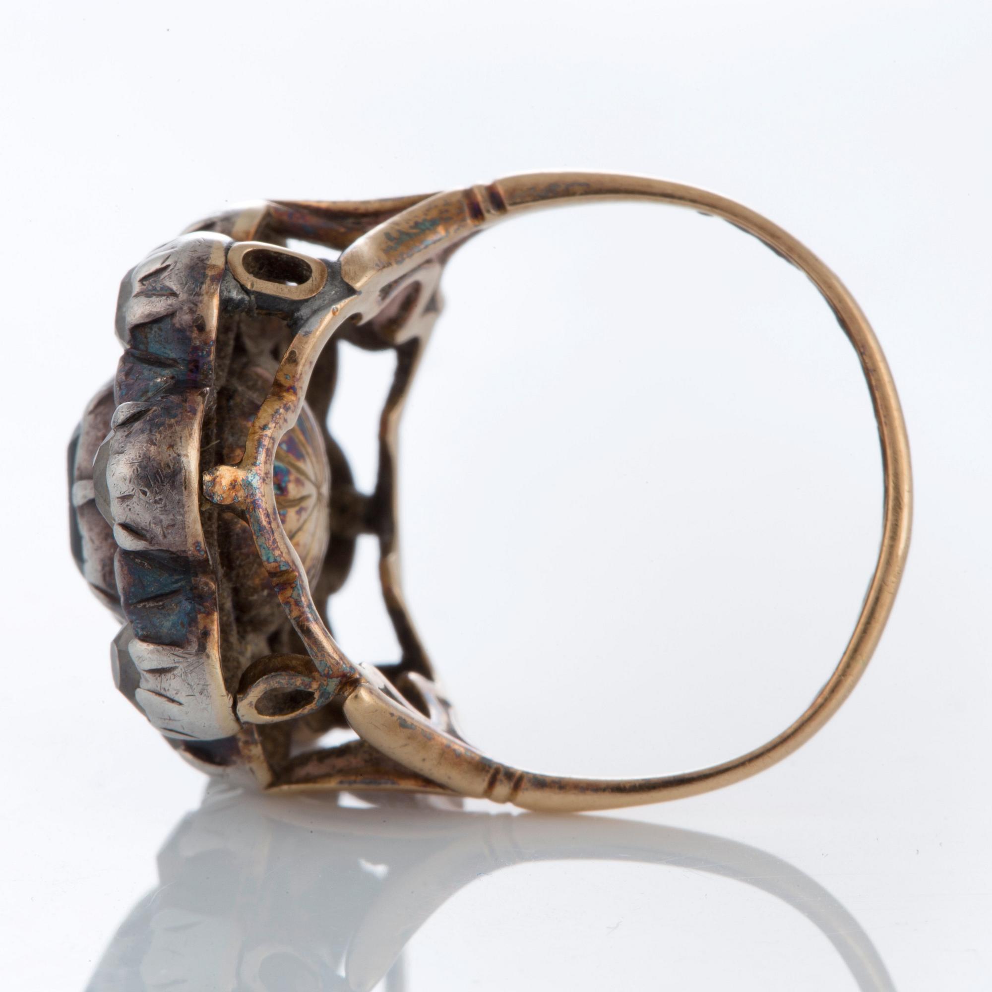 A ring set with an emerald and old-cut diamonds.
