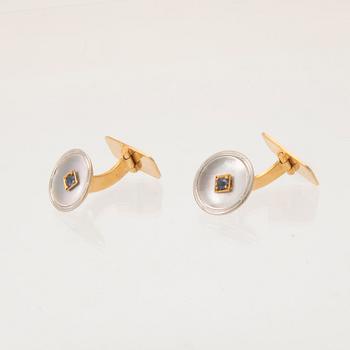 Dress and cufflinks in 18K white and red gold with mother of pearl, round brilliant-cut diamonds, and blue stones.