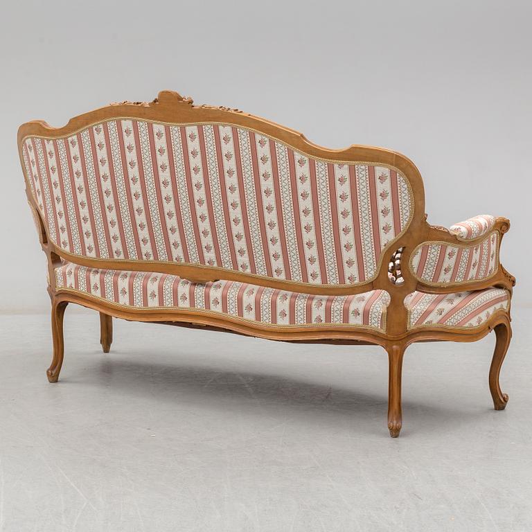 An end of the 19th Century rococo style walnut sofa with four chairs, two armchairs and a table.