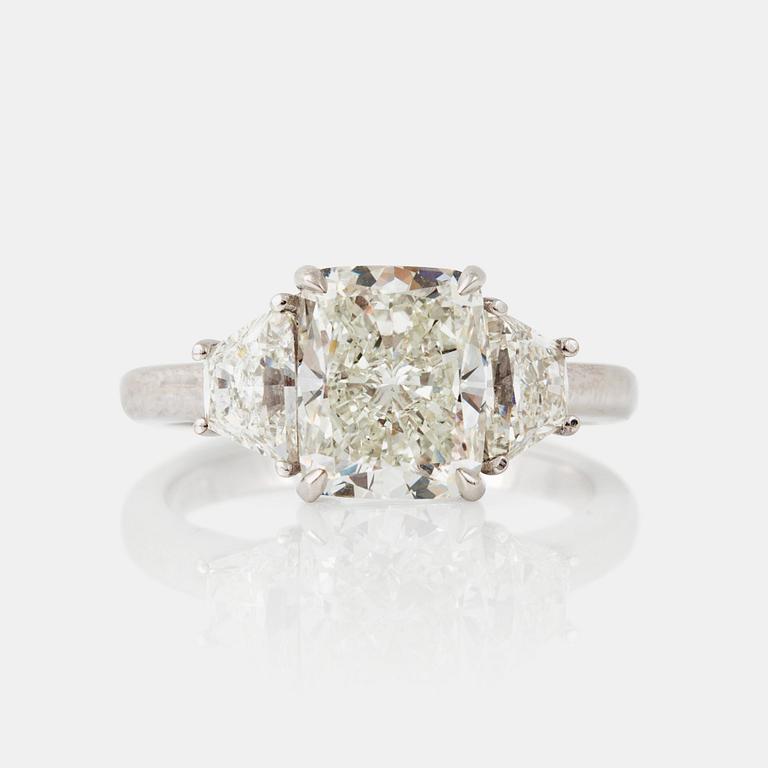 A cushion-cut diamond, 3.01 cts, flanked by two trapezoid-cut diamonds, 1.13 cts, ring.