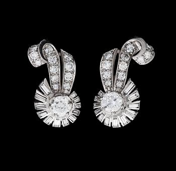 1095. A pair of brilliant- and baguette cut diamond earrings, tot. app. 1.50 cts, 1940's.