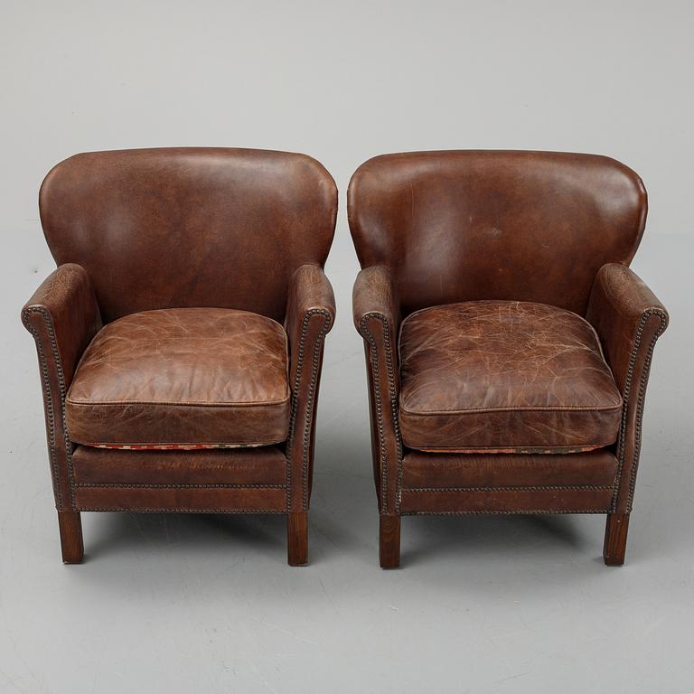 A pair of Artwood leather easy chairs.