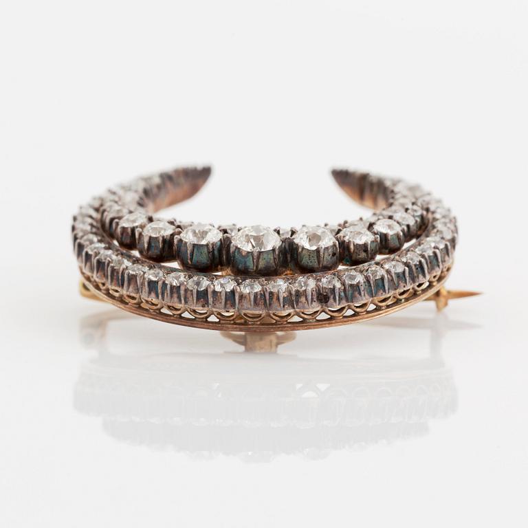 A crescent moon brooch in silver and gold set with old- and rose-cut diamonds.