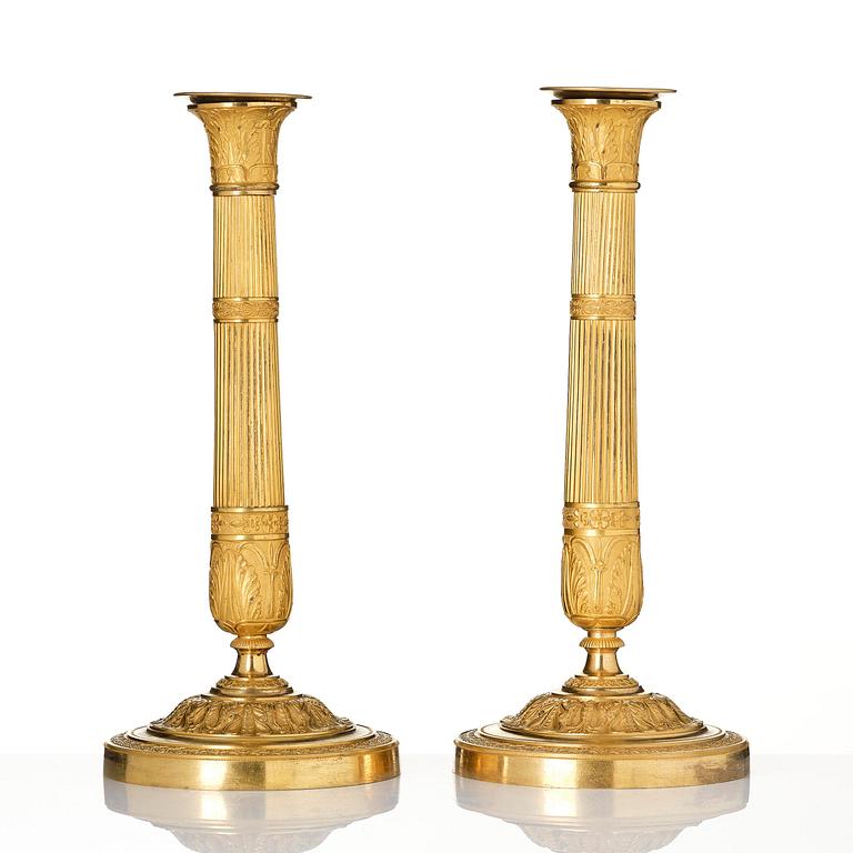 A pair of French Empire ormolu candlesticks, early 19th century.