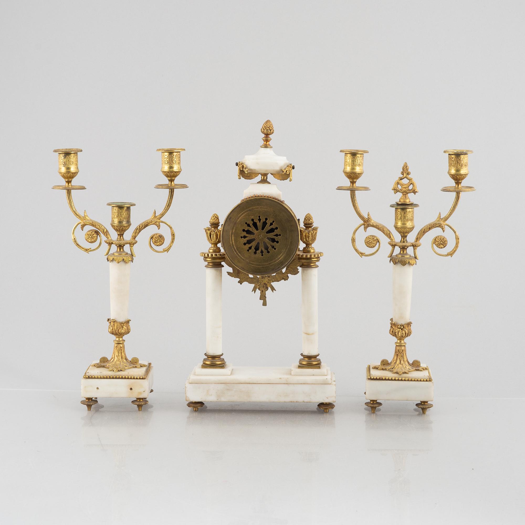 A Louis XVI-style mantel clock Paris, France and a pair of candelabras, late 19th century.