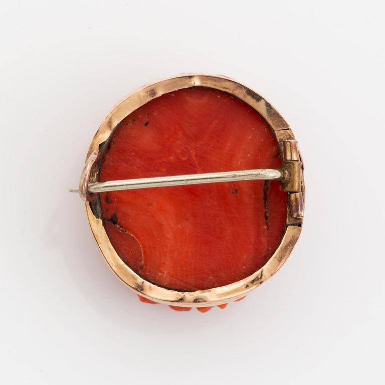 A 14K gold and coral cameo brooch.