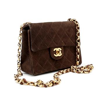 CHANEL, a brown suede quilted purse with shoulder strap.