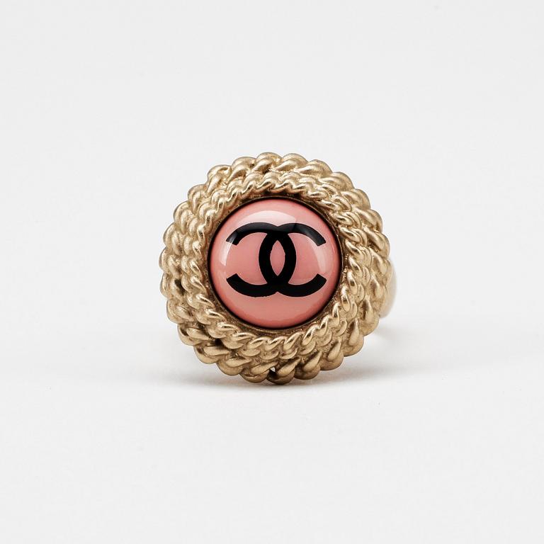 CHANEL, a gold colored logo ring.