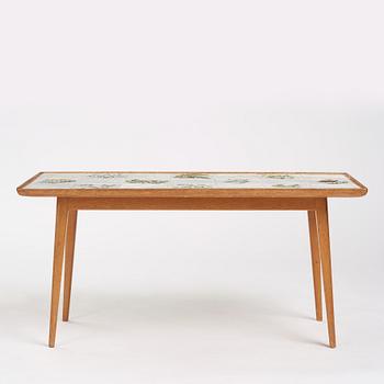 a Swedish Modern coffee table, decorated with Jobs' ceramic tiles, signed and dated 1941.