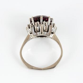 RING, 18K vitguld med fasetterad granat tot ca 3,68 cts omgiven av briljantslipade diamanter tot ca 0,4 ct. Vikt 6,91 g.