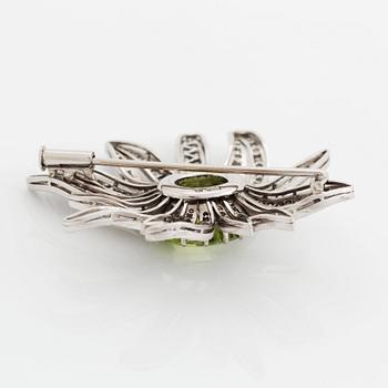 An 18K white gold brooch set with a faceted peridot and eight-cut diamonds.