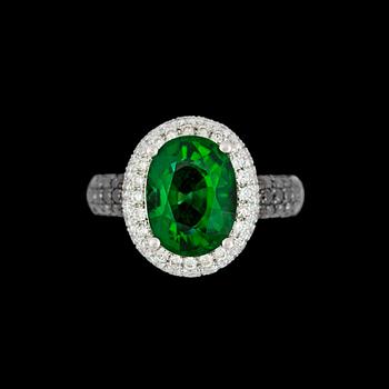 267. A green tourmaline ring, 3.93 cts, set with black and white brilliant cut diamonds, tot. 0.48  / 1.12 cts.